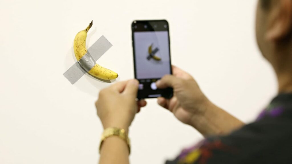 Visitante come banana da obra milionária de Maurizio Cattelan, exposta em museu