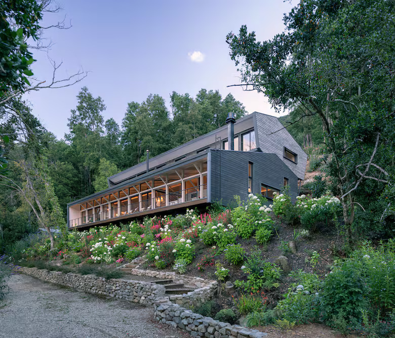 Feita de madeira, uma casa de 11 metros de altura achou seu lugar entre a montanha e o lago