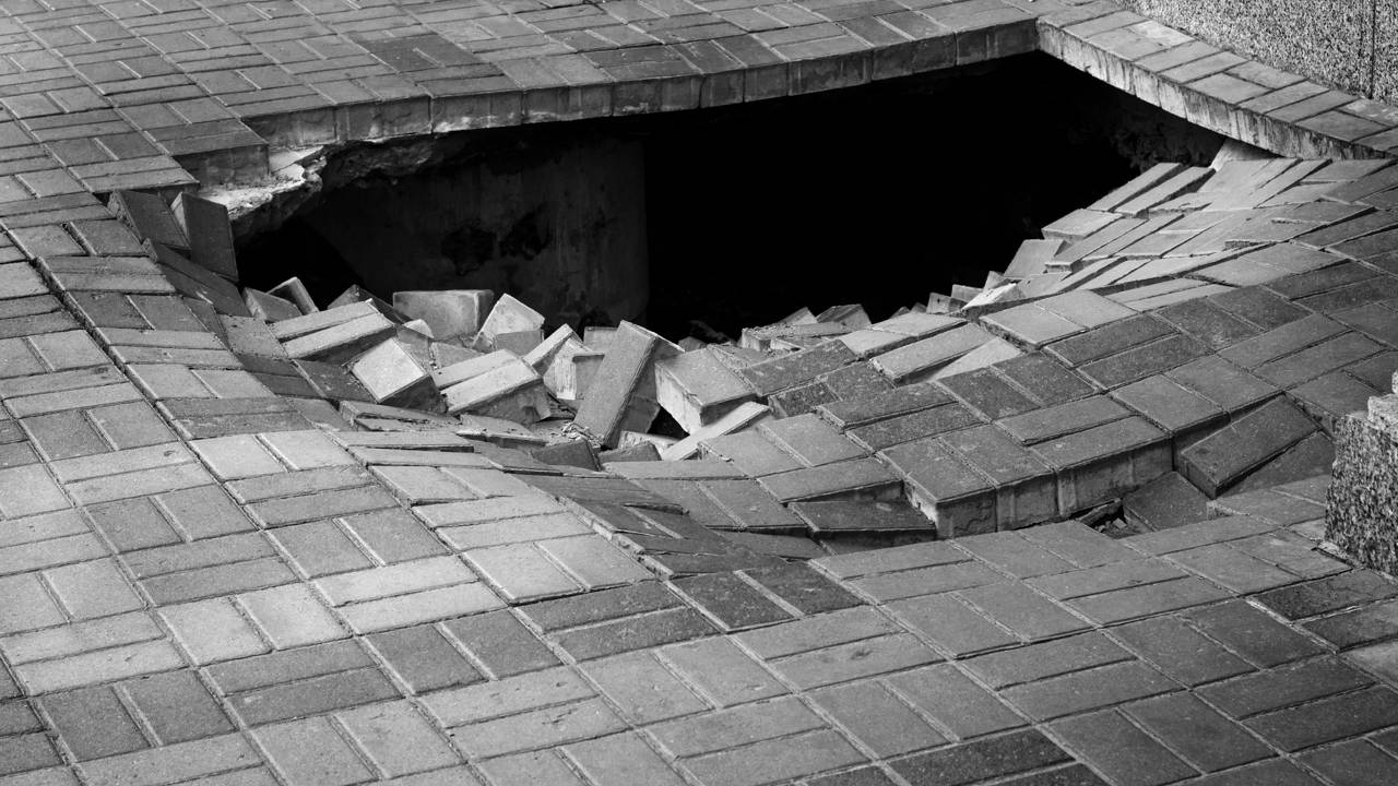Homem precisa ser resgatado após buraco gigante se abrir em calçada