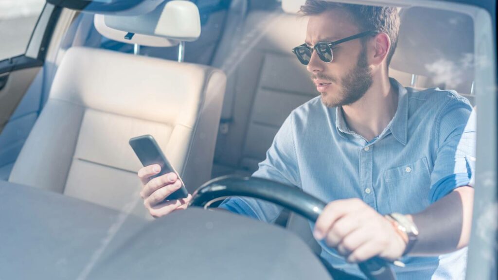 Utilizar o celular, mesmo com o carro parado no trânsito, ainda é infração - Créditos: depositphotos.com / ArturVerkhovetskiy