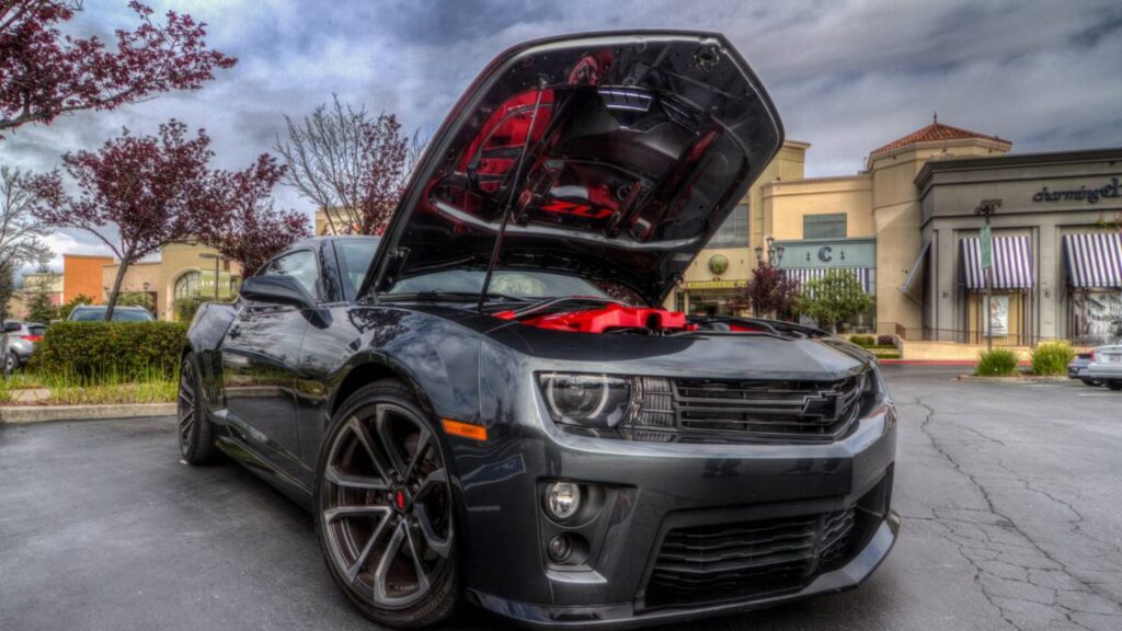 Camaro SS cinza com o capô aberto revelando motor