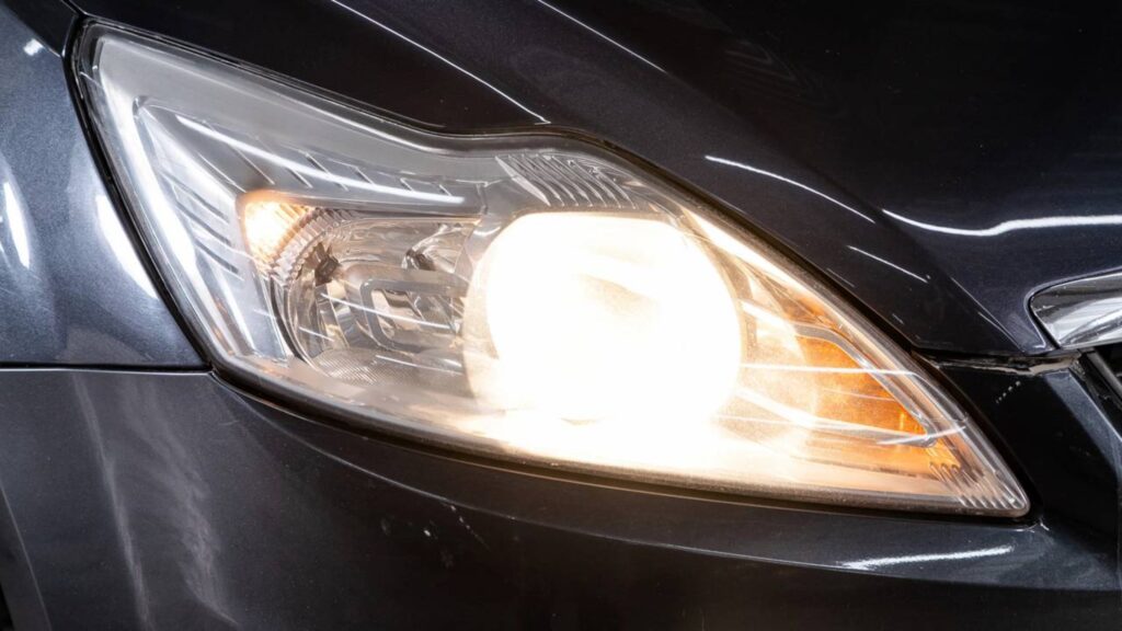 Farol de carro aceso durante o dia - Créditos: depositphotos.com / everyonensk