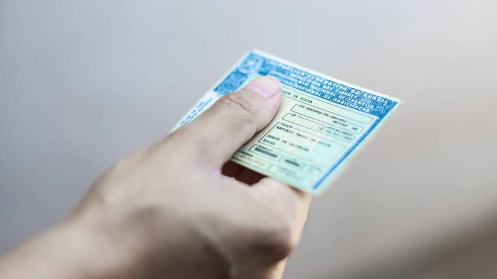 Pessoa segurando documento de Habilitação de Motorista no Brasil
