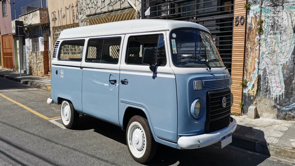 VW Kombi azul estacionada em frente a uma casa em bairro residencial