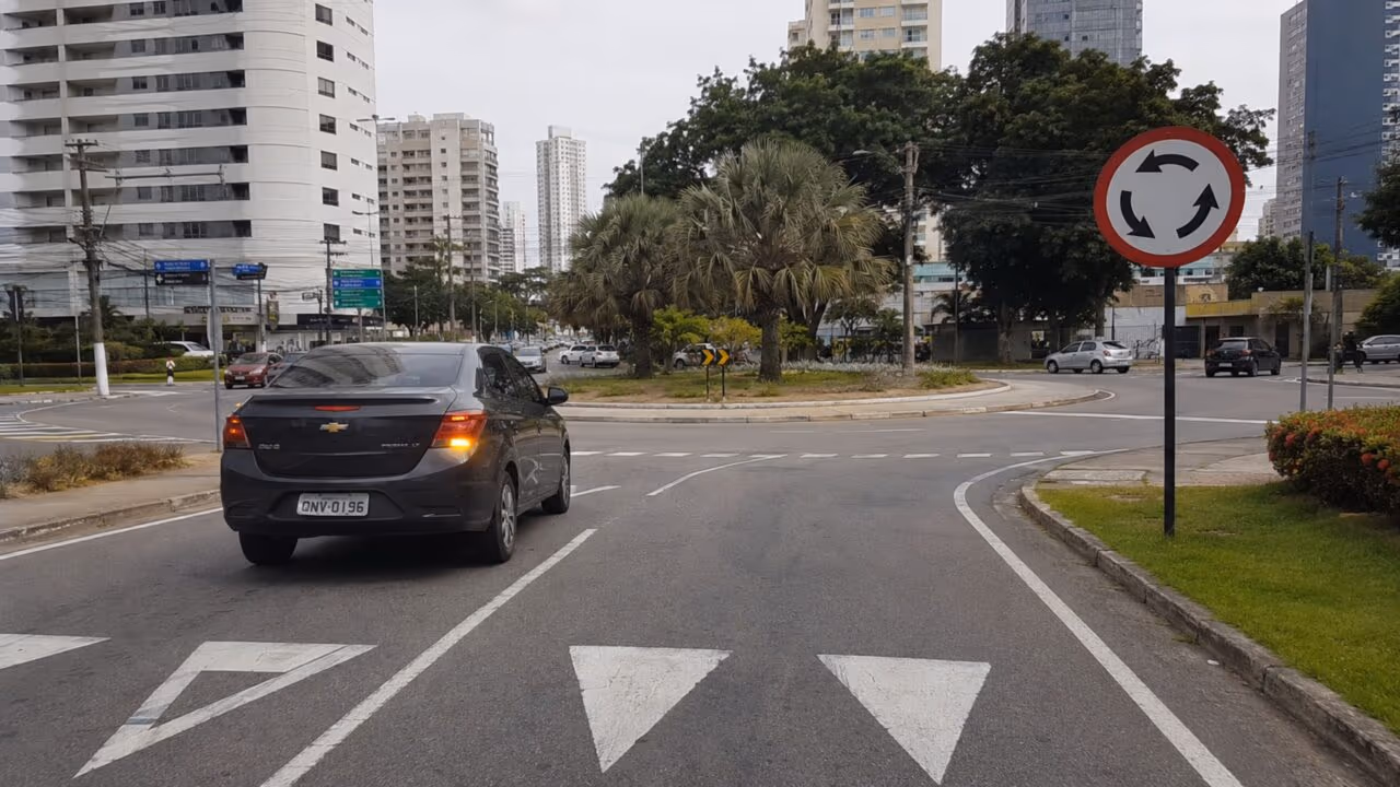 O que significa a placa de trânsito com fundo branco e 3 setas em sentido circular?