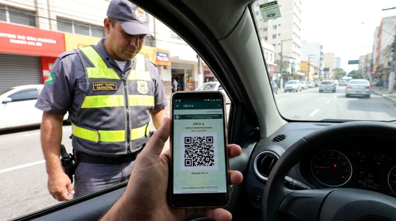 Motorista é parado na blitz de trânsito, ao ser requisitado o documento do carro ele apresenta o CRLV-e no celular e é questionado por agente, condutor afirma não carregar mais o licenciamento impresso