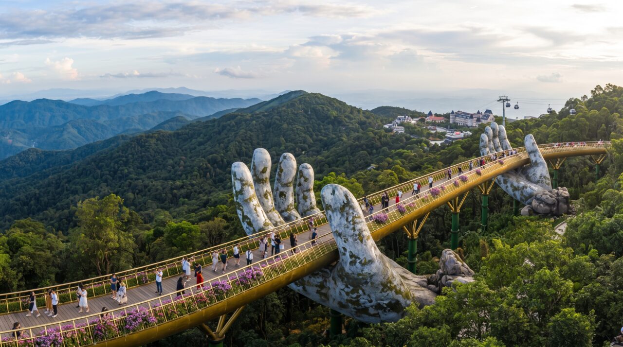 Sustentada por duas mãos de pedra colossais que parecem emergir da montanha, esta passarela dourada atrai milhares de visitantes para caminhar literalmente sobre as nuvens