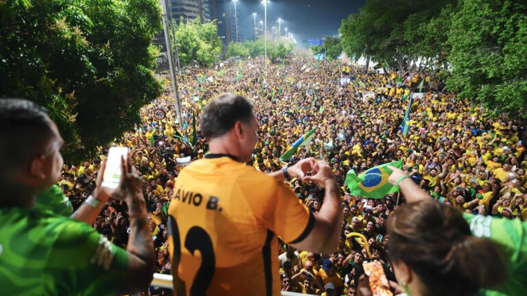Flávio Bolsonaro faz gesto de coração em comício
