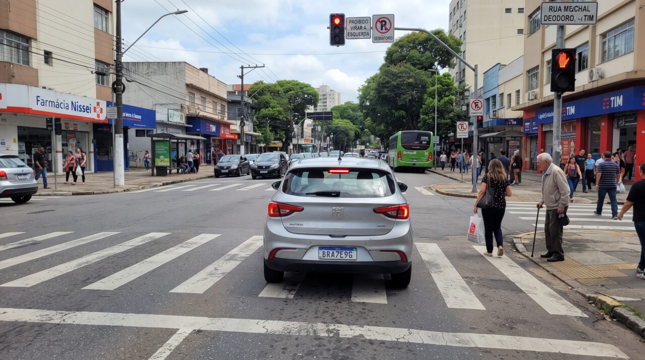 Infração e multa por parar o carro em cima da faixa de pedestres no sinal amarelo.