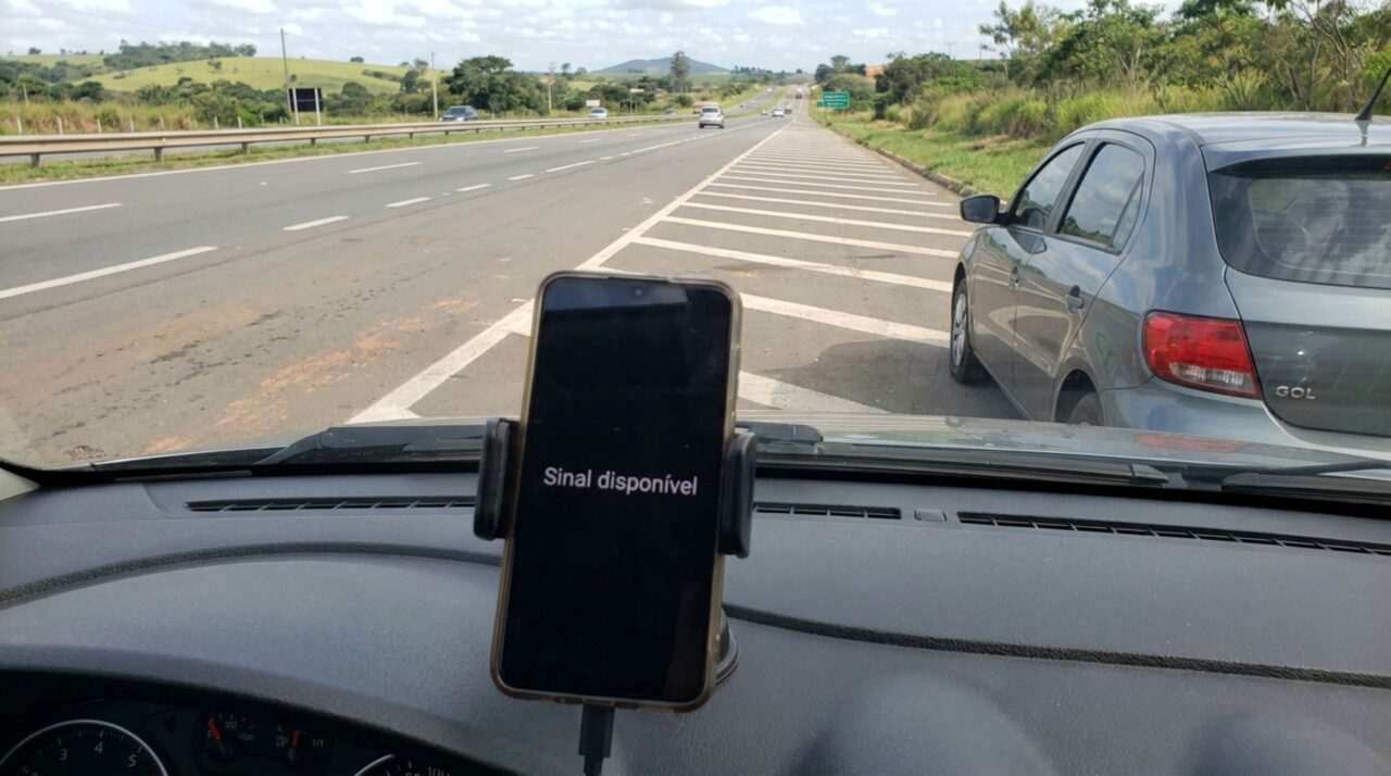Motorista entra no acostamento para buscar sinal de celular e avisar que chegará atrasado, mas é parado por fiscalização e descobre por que a dificuldade de comunicação não libera o acostamento