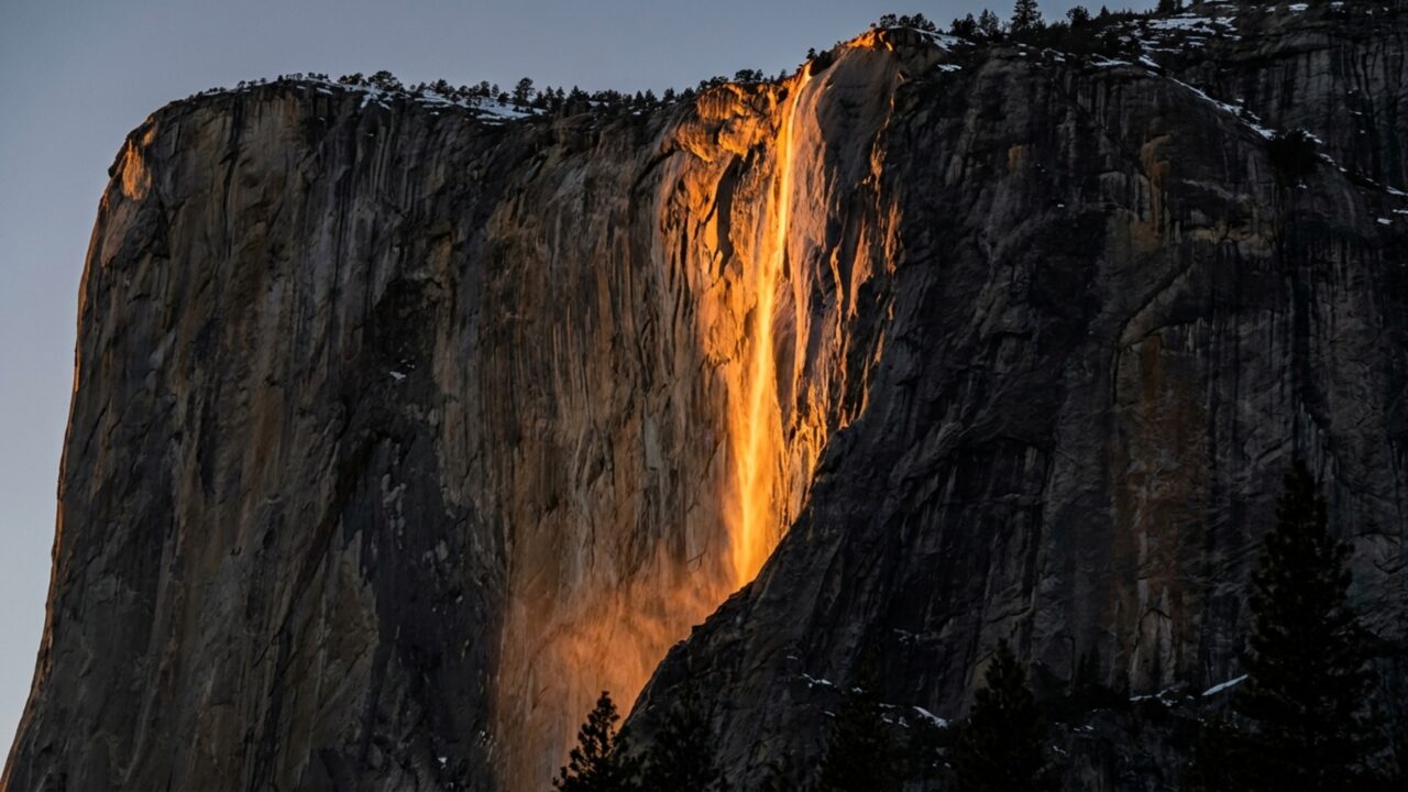 Uma cachoeira de 300 metros parece virar lava por alguns minutos quando o Sol ilumina uma montanha