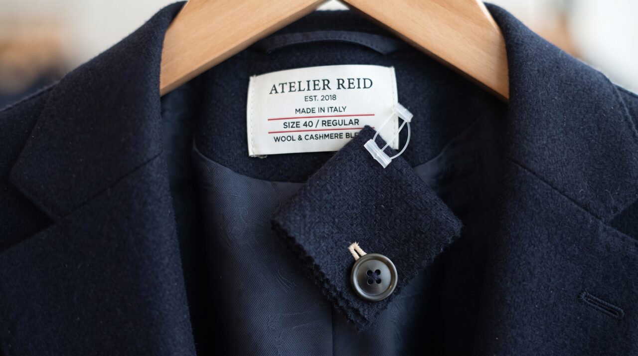 O que significa aquele pequeno pedaço de tecido extra que vem costurado na etiqueta de algumas roupas novas?