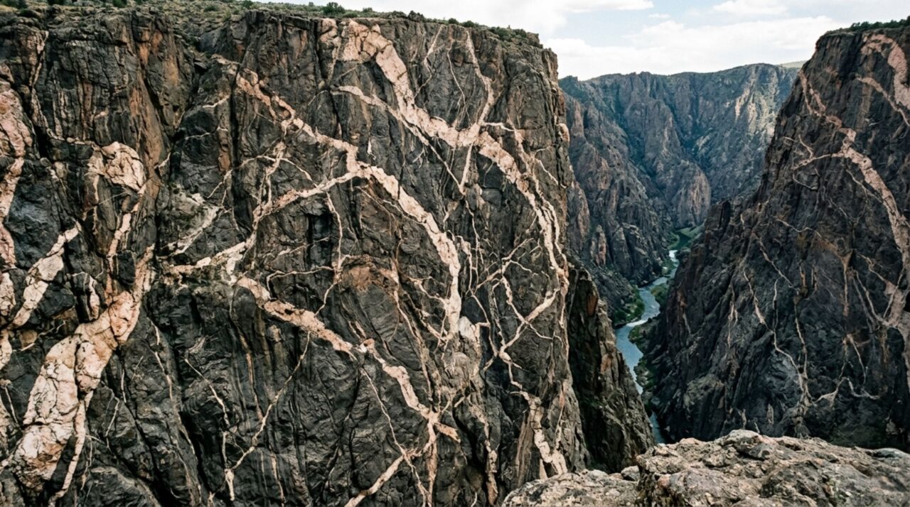 Veios claros de pegmatito registram antigos episódios magmáticos nas paredes do Black Canyon