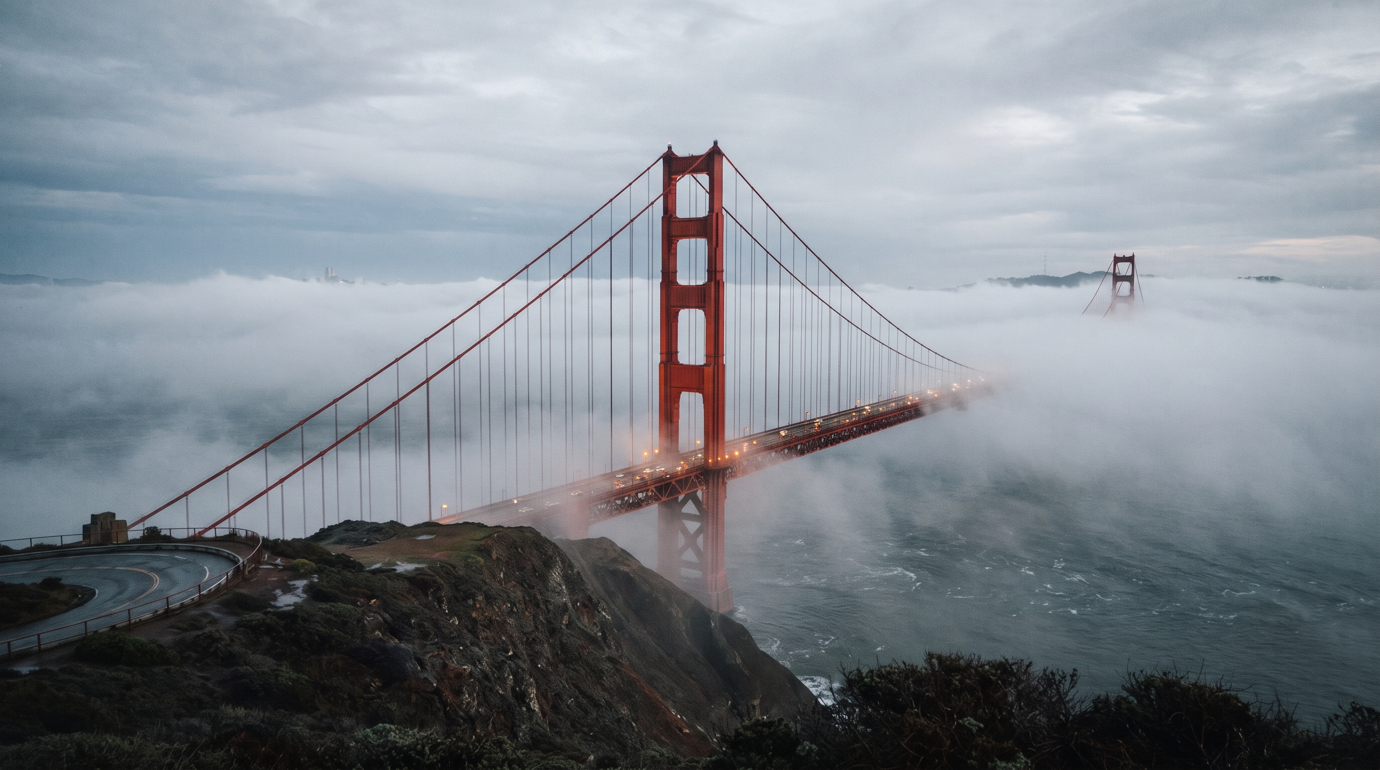 Suspensa por dois cabos principais colossais que contêm mais de 129 mil quilômetros de fios de aço galvanizado, a icônica ponte pênsil vermelha de 2,7 quilômetros foi erguida desafiando as névoas e correntes brutais do Pacífico