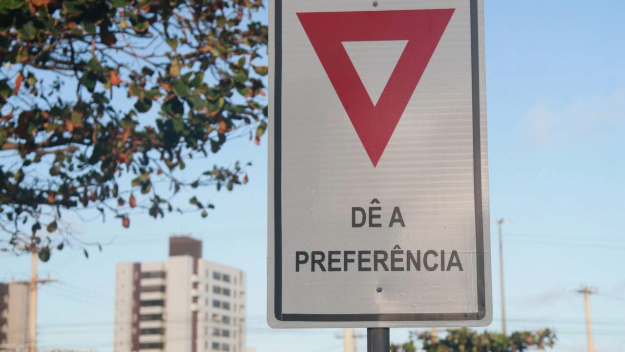 O que significa o triângulo de ponta-cabeça com fundo branco e borda vermelha, a placa que muita gente confunde com “atenção” e que obriga o motorista a parar se vier alguém