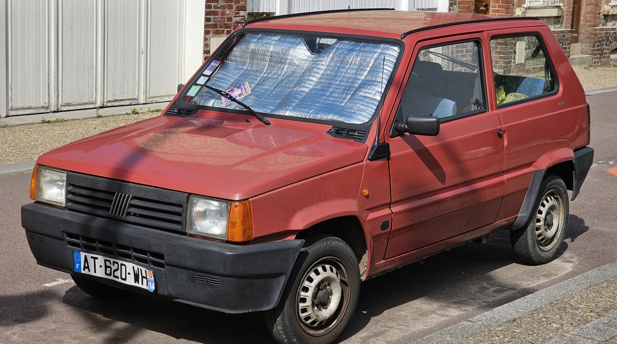 Fiat Panda vermelho de primeira geração estacionado numa rua